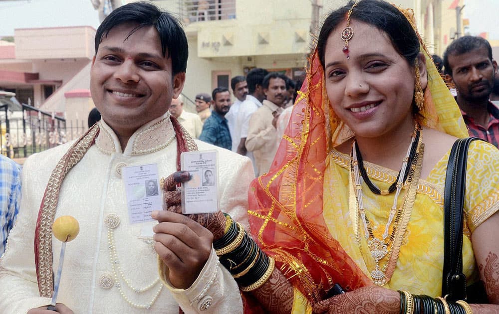 A newly wed couple arrives to cast votes for Lok Sabha elections at a polling station in Hubli.