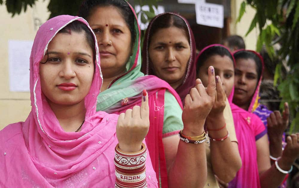 Women show their inked fingers after casting votes at a polling station at Hiranagar during the fifth phase of polling for Lok Sabha elections in Kathua.