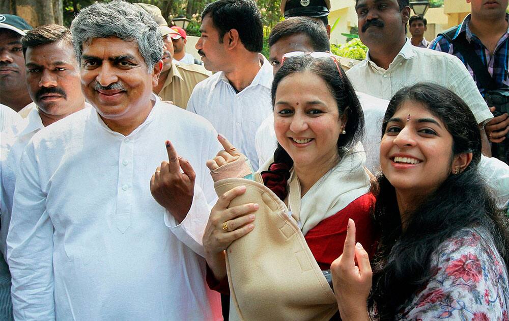 Congress candidate from Bangalore South Nandan Nilekani showing inked finger with his wife Rohini and daughter after casting their votes in Bengaluru.