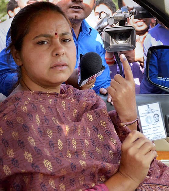 RJD candidate from Patliputra Misa Bharti shows her voter id-card and inked finger after casting her vote at a polling booth in Patna.