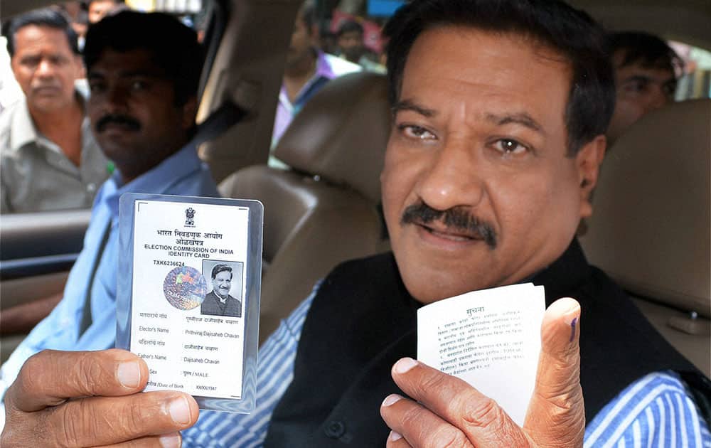 Maharashtra Chief Minister Prithviraj Chavan shows his voter identity card after casting his vote for Lok Sabha polls in Karad, Maharashtra.