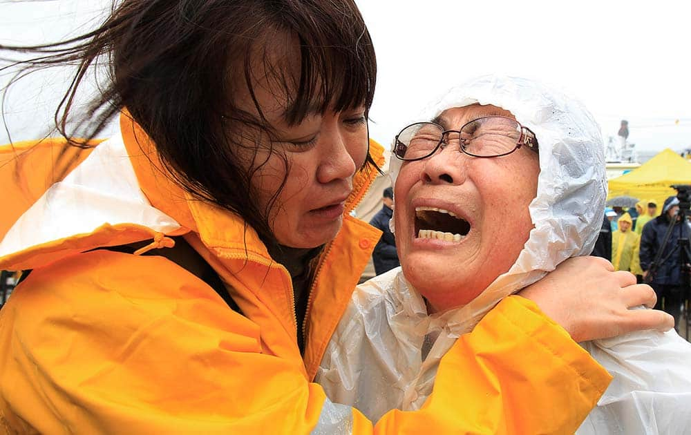 Relatives of a passenger aboard a sunken ferry weep as they wait for the news on the rescue operation, at a port in Jindo, South Korea.