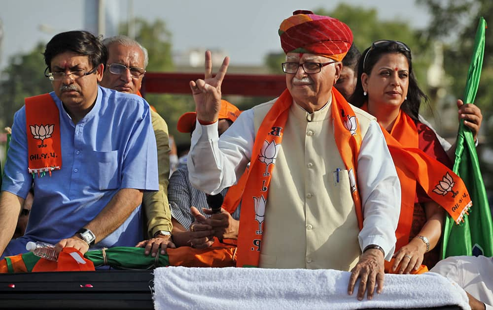 Lal Krishna Advani stands with his son Jayant Advani and daughter Pratibha Advani as he flashes a victory sign during an election campaign road show rally in Ahmadabad.