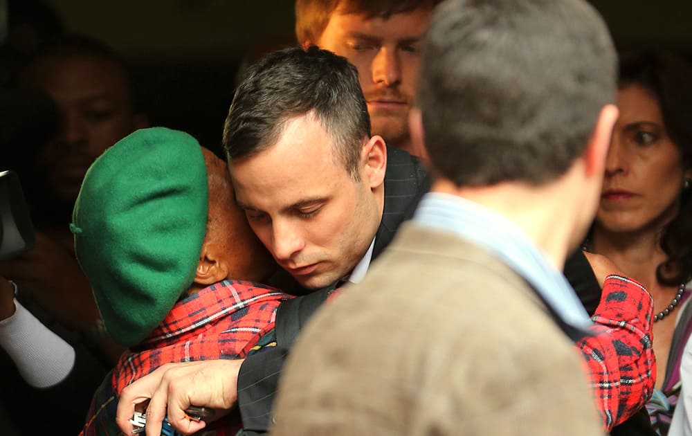 Oscar Pistorius shares a hug with an unidentified woman as he leaves the high court in Pretoria, South Africa.