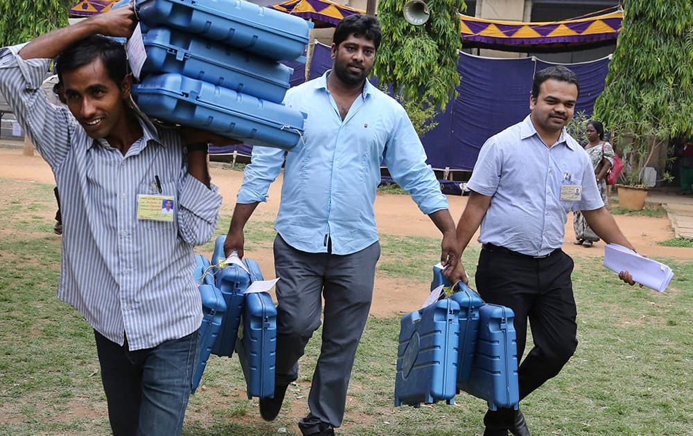 Government employees carry electronic voting machines before distributing them to polling agents ahead of the sixth phase of Indian parliamentary elections in Bangalore.