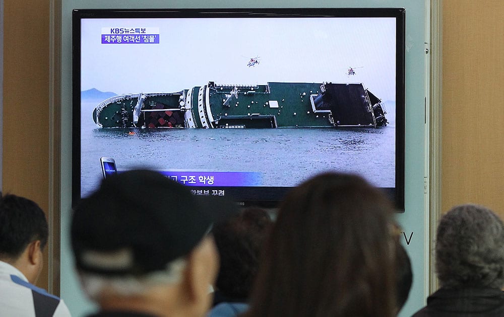 People watch a TV news program showing a sinking passenger ship, at Seoul Railway Station in Seoul, South Korea. The South Korean passenger ship carrying more than 470 people, including many high school students, is sinking off the country`s southern coast Wednesday after sending a distress call, officials said. 