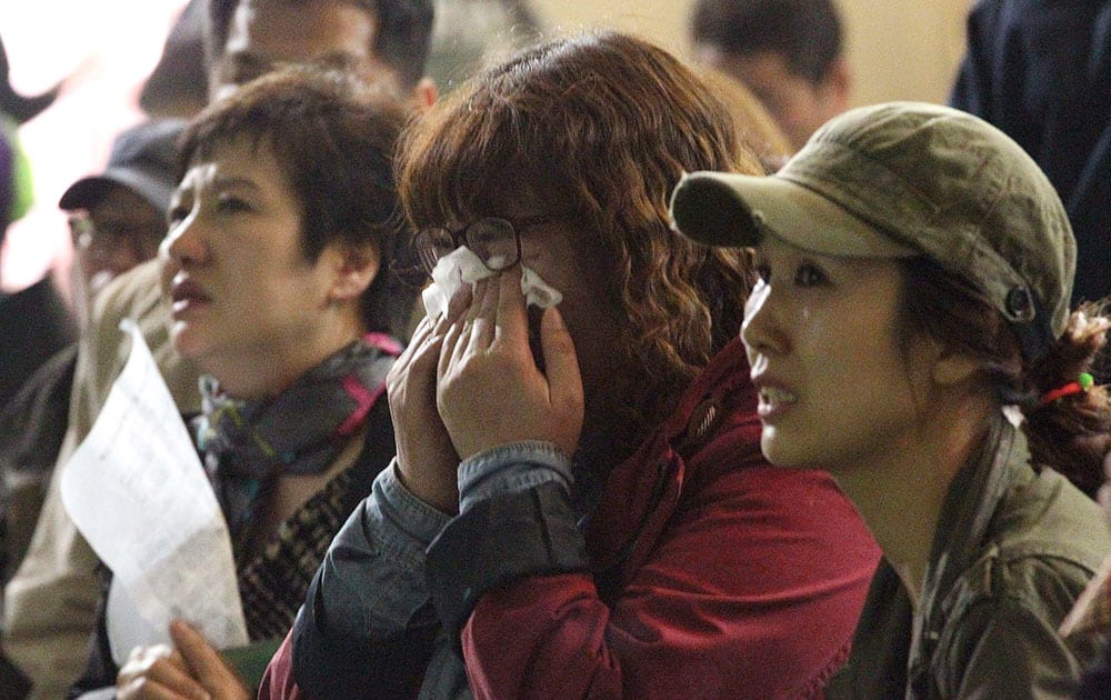 A mother weeps as she and others search for their children`s names among a list of survivors rescued from a ferry that sank off the country`s southern coast, at Danwon high school in Ansan, South Korea.