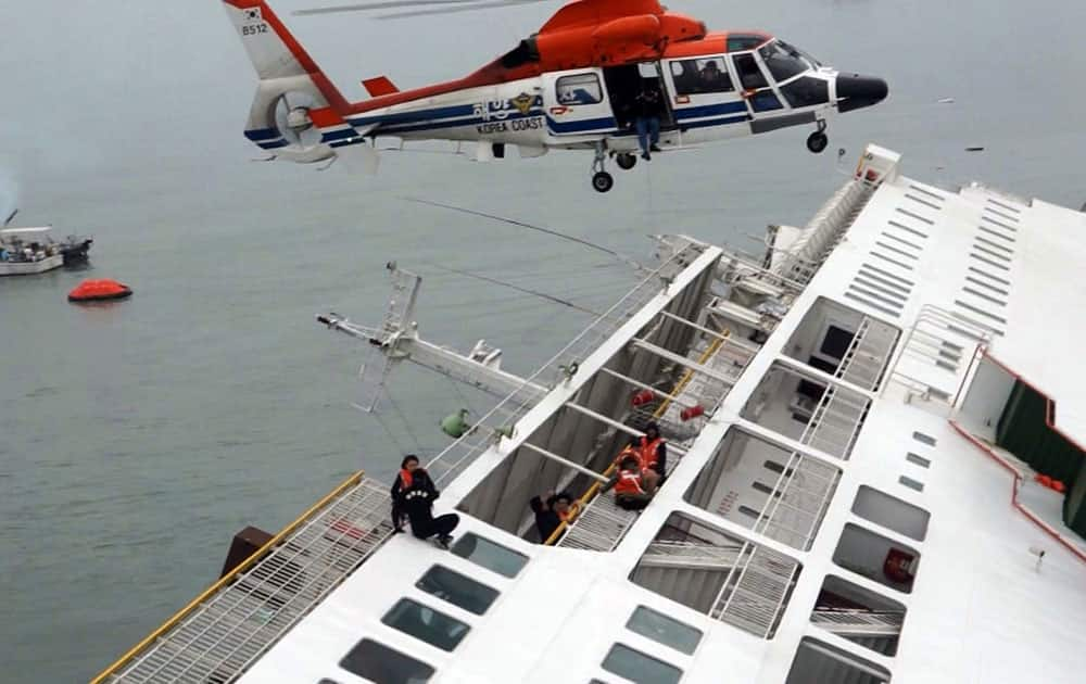 A ferry sinking off South Korea`s southern coast, are rescued by a South Korean Coast Guard helicopter in the water off the southern coast near Jindo, south of Seoul.