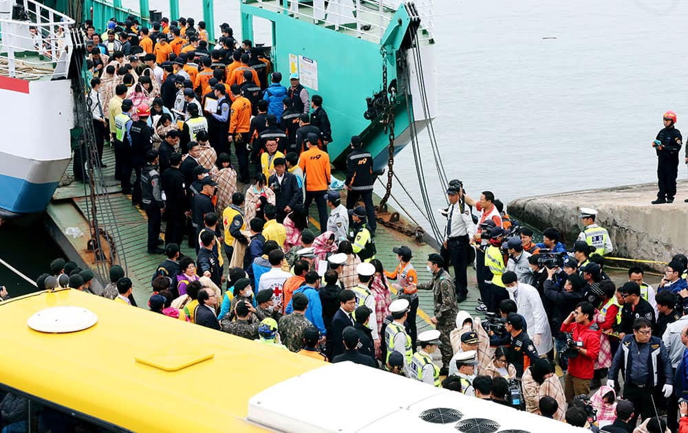 Rescued passengers are escorted by members of a rescue team upon their arrival at a port in Jindo, south of Seoul, South Korea.