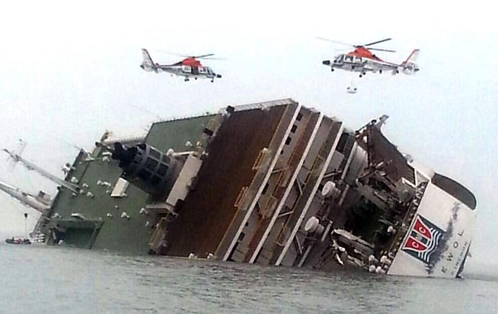 South Korean rescue helicopters fly over a South Korean passenger ship, trying to rescue passengers from the ship in water off the southern coast in South Korea.