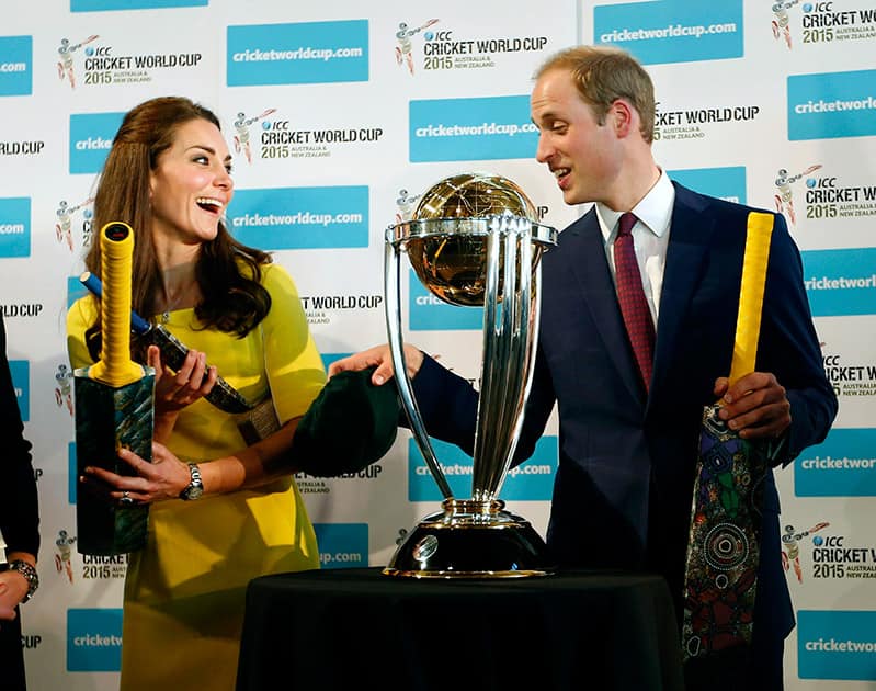 Britain`s Prince William, right, and his wife Kate, the Duchess of Cambridge, hold cricket bats presented to them in front of the Cricket World Cup during a reception at the Sydney Opera House.