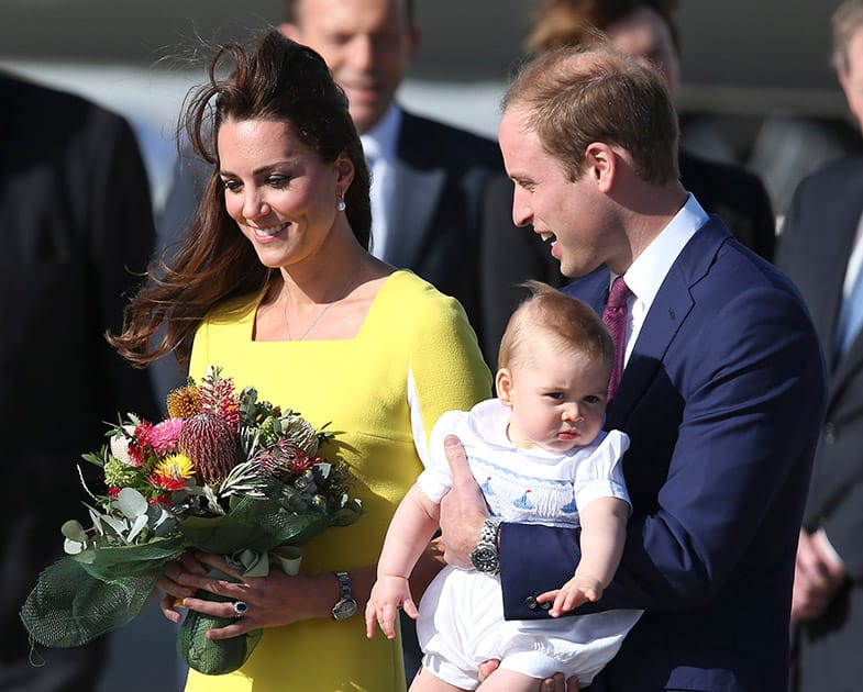 Britain`s Prince William holding his son Prince George and his wife Kate, Duchess of Cambridge, arrive in Sydney.