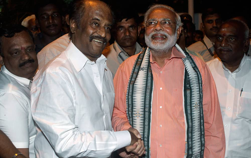 Narendra Modi shakes hands with Rajnikanth before addressing an election campaign rally in Chennai.