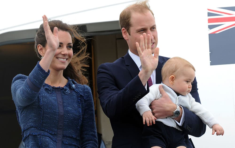 Britain`s Prince William carries Prince George with his wife Kate, the Duchess of Cambridge as they depart for Sydney, Australia, from Wellington, New Zealand.