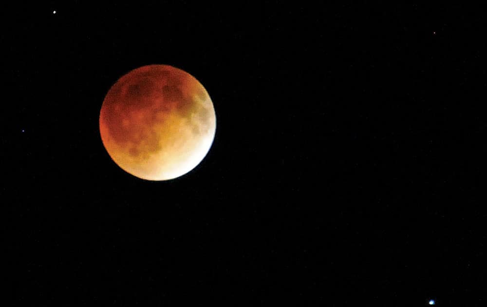 The full moon turns a coppery red as it passes into Earth`s shadow during a total lunar eclipse, seen near Enid, Ola. Unlike solar eclipses, lunar eclipses are safe to view with the naked eye and don`t require special filters.  