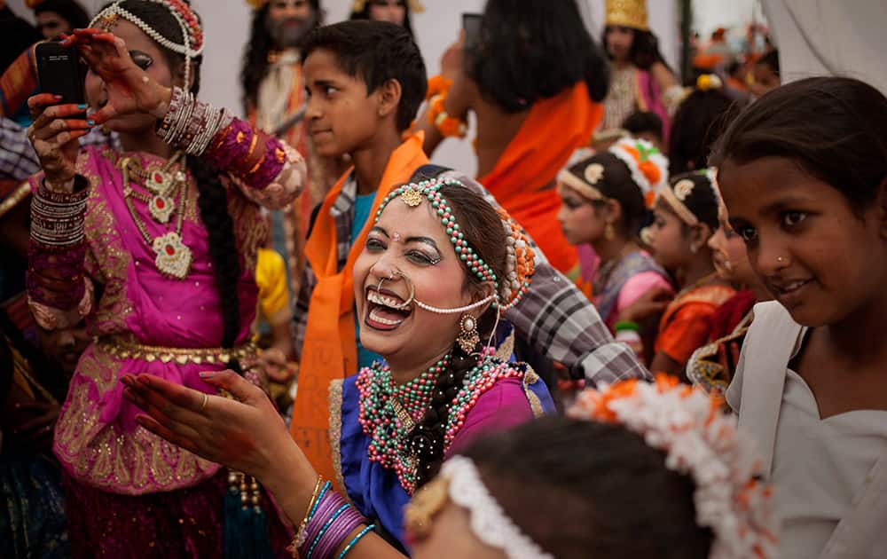 A girl laughs as she waits to participate in a procession during Hanuman Jayanti in New Delhi.