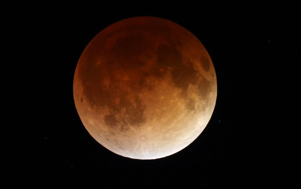 The moon glows a red hue during a total lunar eclipse as seen from the Milwaukee area. Tuesday`s eclipse is the first of four total lunar eclipses that will take place between 2014 to 2015.