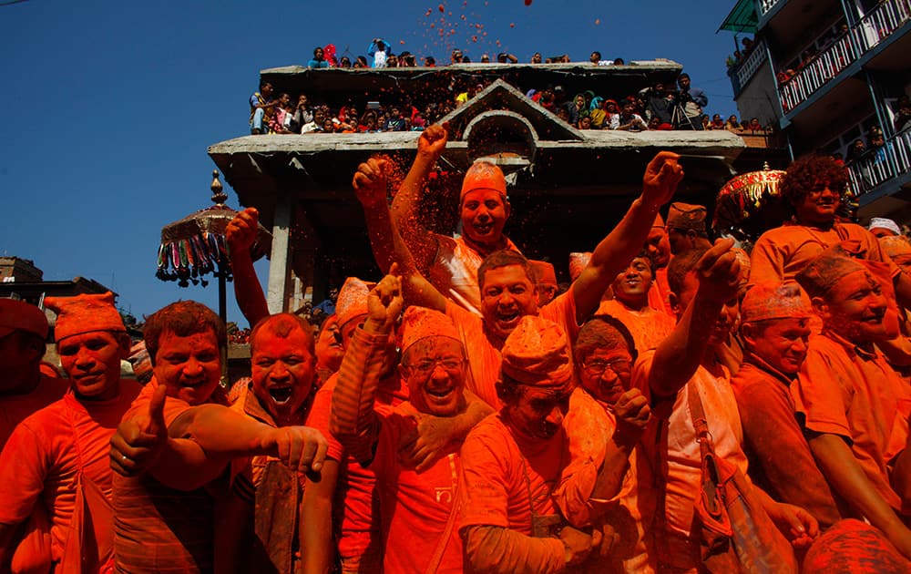 Nepalese men throw sindoor, or vermillion powder to celebrate Sindoor Jatra festival in Bhaktapur, Nepal.