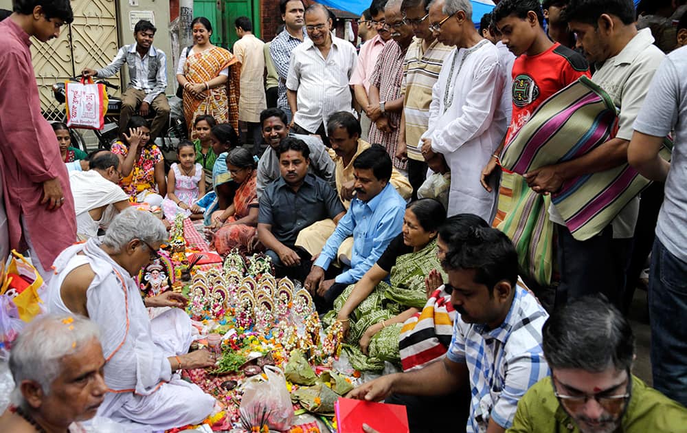 Devotees surround Hindu priests with deities of Ganesha, the elephant-headed God, and Goddess of wealth Laxmi to perform rituals to mark Bengali New Year in Kolkata.