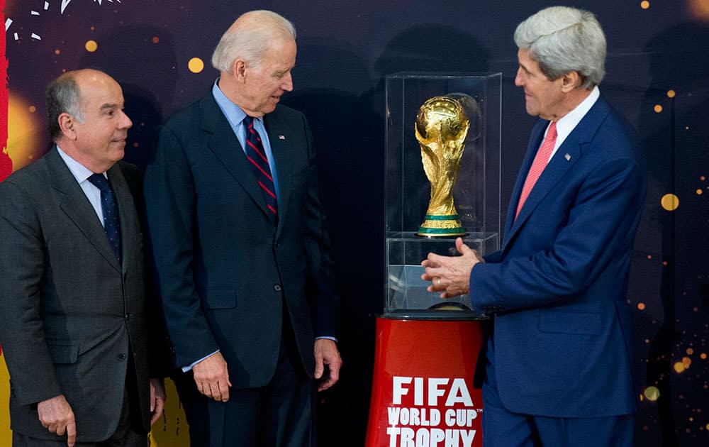 From left, Brazil`s Ambassador to the US Mauro L.I. Vieira, Vice President Joe Biden, and Secretary of State John Kerry, look at the FIFA World Cup trophy, the actual trophy that will be awarded to the winner of this year’s World Cup soccer tournament in Brazil, during an unveiling ceremony at the State Department in Washington. 