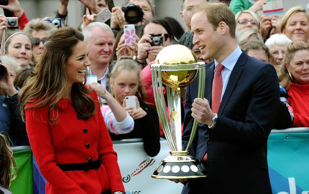 Britain`s Prince William holds the Cricket World Cup trophy as his wife Kate, the Duchess of Cambridge, smiles during a promotional event at Latimer Square during their visit to Christchurch, New Zealand.