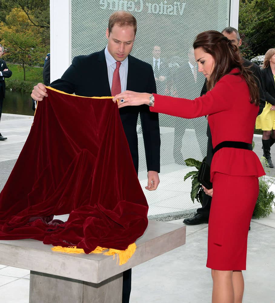 Britain`s Prince William, left, and his wife Kate, the Duchess of Cambridge, unveil a plaque during a ceremony to open the new visitors center at the Christchurch botanical gardens in Christchurch, New Zealand.
