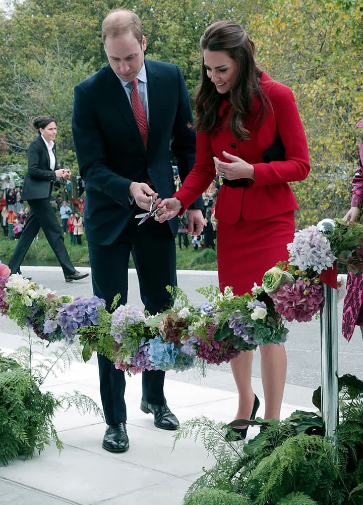 Britain`s Prince William, left, and his wife Kate, the Duchess of Cambridge, cut a ribbon during a ceremony to open the new visitors center at the Christchurch botanical gardens in Christchurch New Zealand.