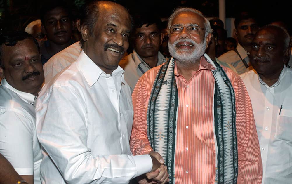 Bharatiya Janata Party (BJP)`s prime ministerial candidate Narendra Modi, second right, shakes hands with Indian film star Rajnikanth before addressing an election campaign rally in Chennai.
