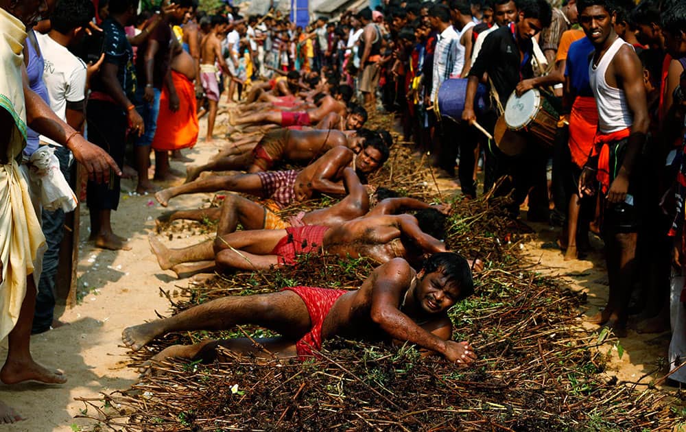 Indian villagers roll on wild thorns placed on road to punish themselves as part of a ritual during the annual Danda festival or the festival of self punishment in Khurda village some 15 miles from the eastern Indian city Bhubaneswar.