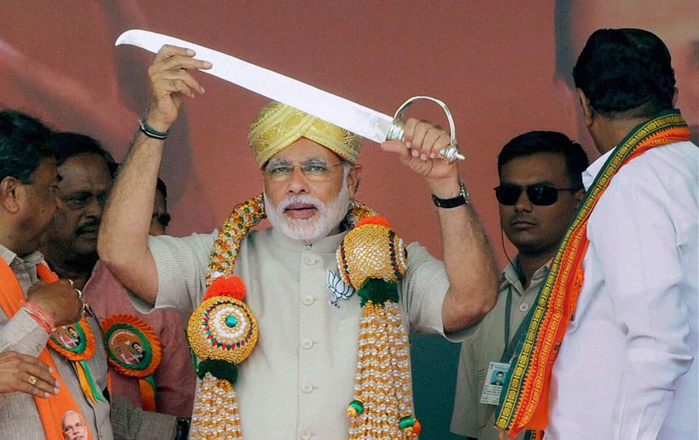 BJP Prime Minister candidate Narendra Modi being presented a sword at a public rally to campaign for BJP candidate B N Bachegowda at Chikkaballapur near Bengaluru.