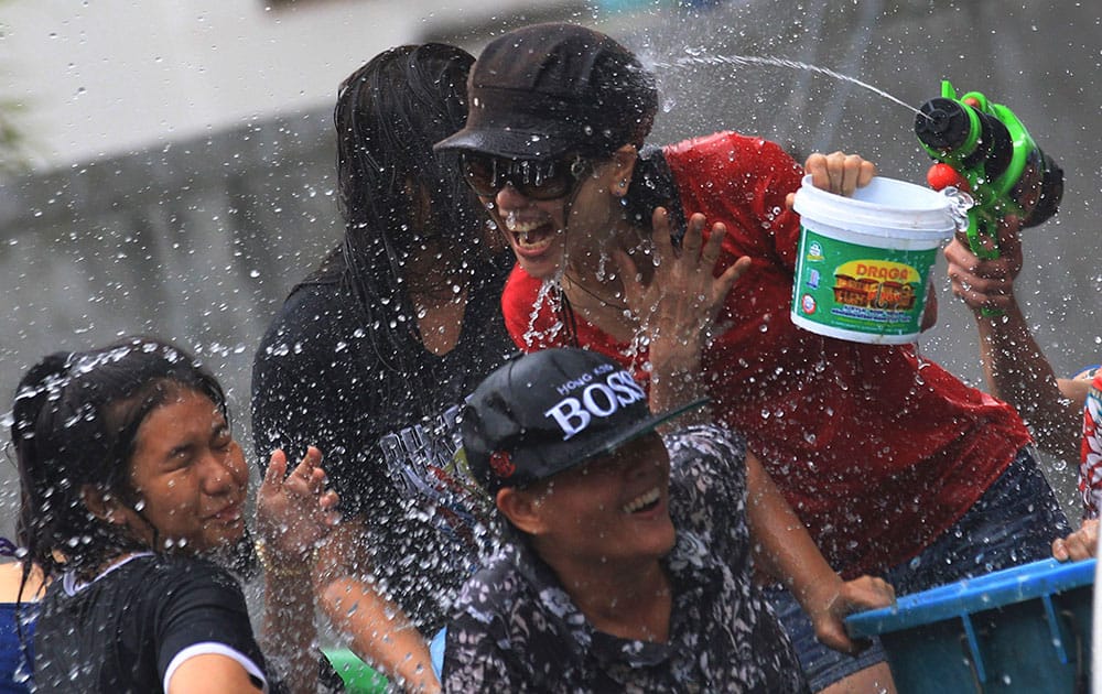 Peoples on a truck react upon being splashed water while others shoot back water guns during during traditional Thai New Year celebrations or Songkran festival in Bangkok.