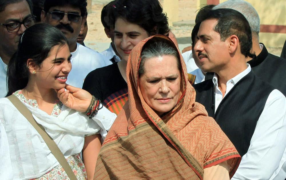 Congress President Sonia Gandhi looks on as her son in law Robert Vadra and dauther Priyanka Vadra admire their daughter Maira (L) after Congress Vice President Rahul Gandhi (unseen) files his nomination papers for Amethi parliamentary seat, in Amethi.