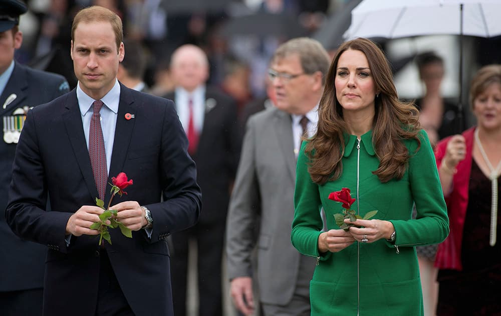 Britain`s Prince William and his wife Kate, Duchess of Cambridge, walk to offer roses to the war memorial in Cambridge, New Zealand.