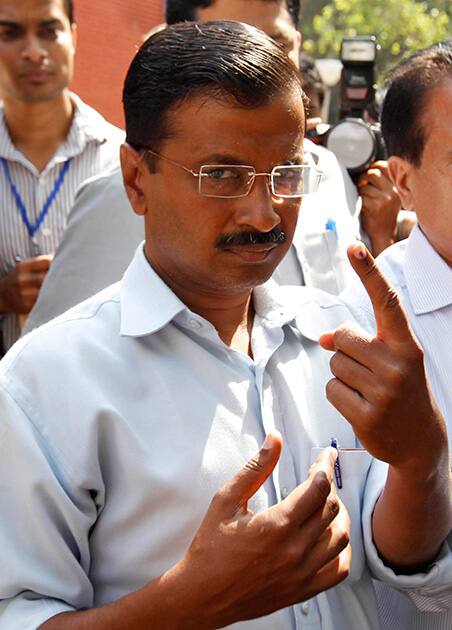 Arvind Kejriwal displays the indelible ink mark on his finger after casting his vote, outside a polling station in New Delhi.