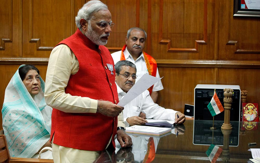 Narendra Modi takes an oath as he files his nomination for the upcoming general election in Vadodara.