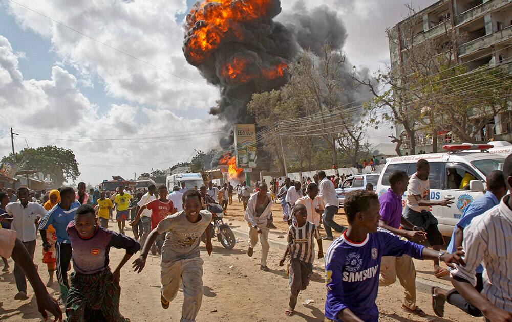 Somalis run from a fireball and explosion during a market fire in the capital Mogadishu, Somalia.