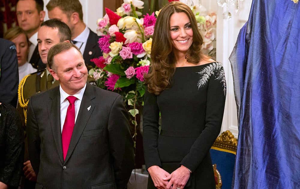 Britain`s Kate, the Duchess of Cambridge, right, and New Zealand`s Prime Minister John Key smile during the unveiling of a portrait of Queen Elizabeth II during a State reception at Government House in Wellington, New Zealand.