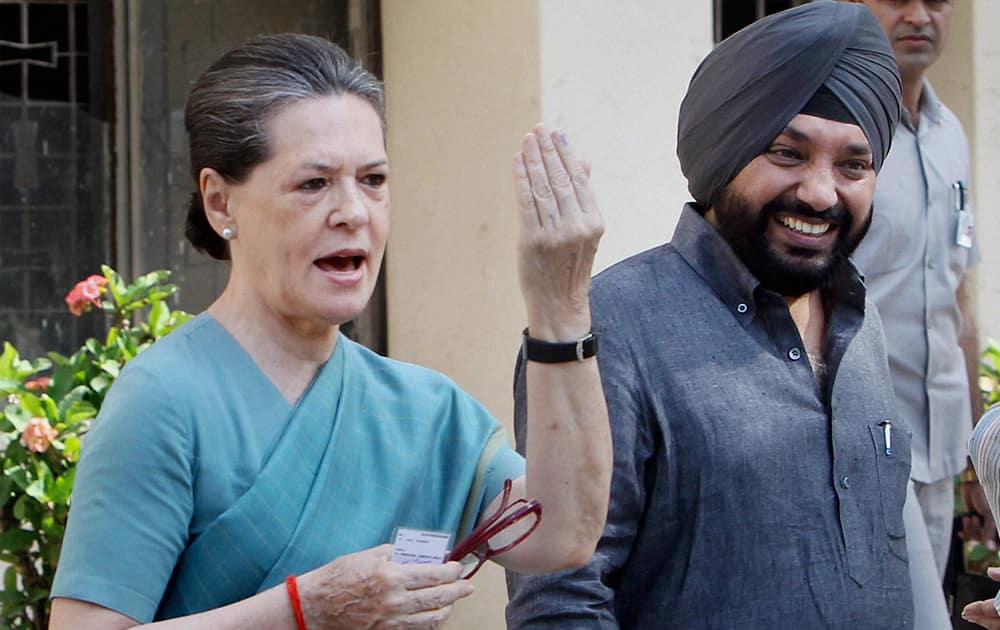 Congress President Sonia Gandhi shows her ink-marked finger after casting vote at Nirman Bhawan polling station in New Delhi during the voting for the third phase of the Lok Sabha elections. DPCC chief Arvinder Singh Lovely is also seen.