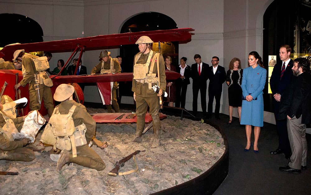 Britain`s Prince William, second right, and his wife Kate, the Duchess of Cambridge, third right, are guided on a tour of the Omaka Aviation Heritage Centre by film director Peter Jackson, right, in Blenheim, New Zealand.