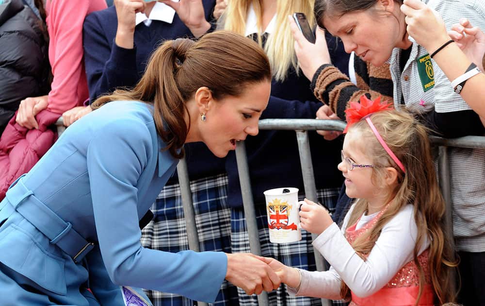 Britain`s Kate, the Duchess of Cambridge, left, chats with a you girl in Seymour Square, Blenhiem, New Zealand.