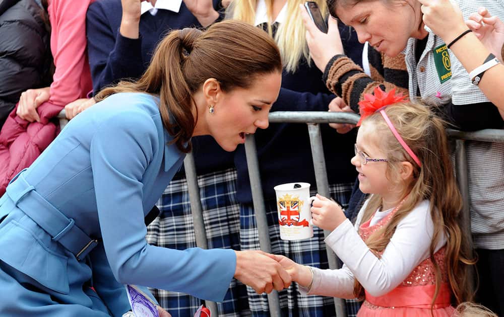 Britain`s Kate, the Duchess of Cambridge, left, chats with a you girl in Seymour Square, Blenhiem, New Zealand.