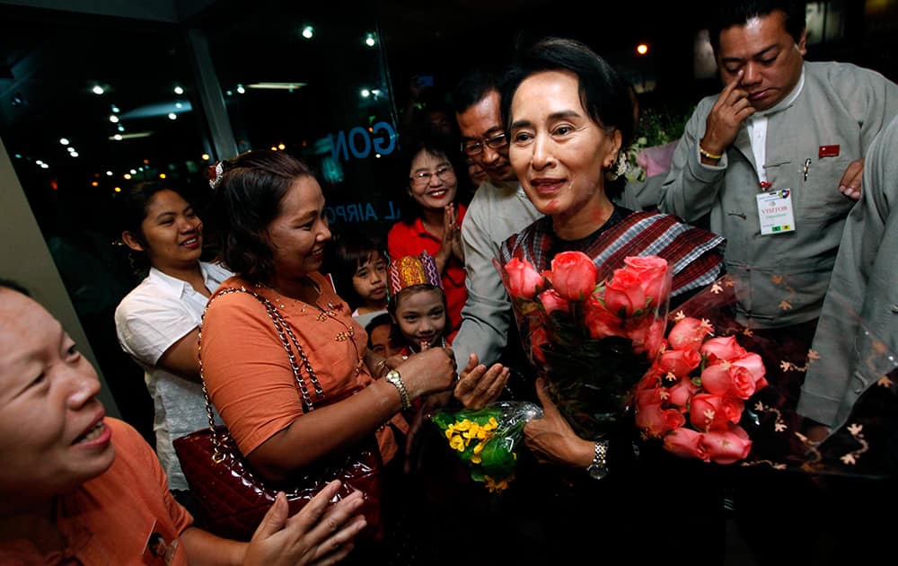 Myanmar Opposition Leader Aung San Suu Kyi, center, arrives at Yangon International Airport to begin her European trip in Yangon, Myanmar.