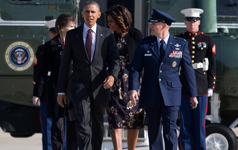President Barack Obama and first lady Michelle Obama walk with Col. William M. Knight from the Marine One helicopter to board Air Force One at Andrews Air Force Base, Md., as they travel to Texas to attend Democratic fundraising events and to visit Fort Hood for a ceremony honoring those injured and killed there last week.