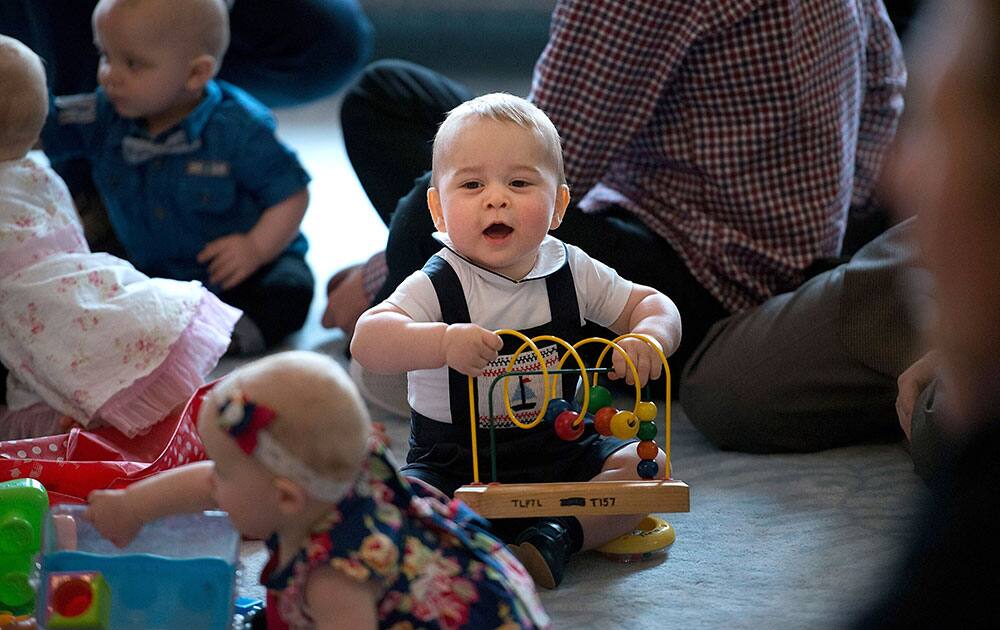 Britain`s Prince George, center, plays during a visit to Plunket nurse and parents group at Government House in Wellington, New Zealand.
