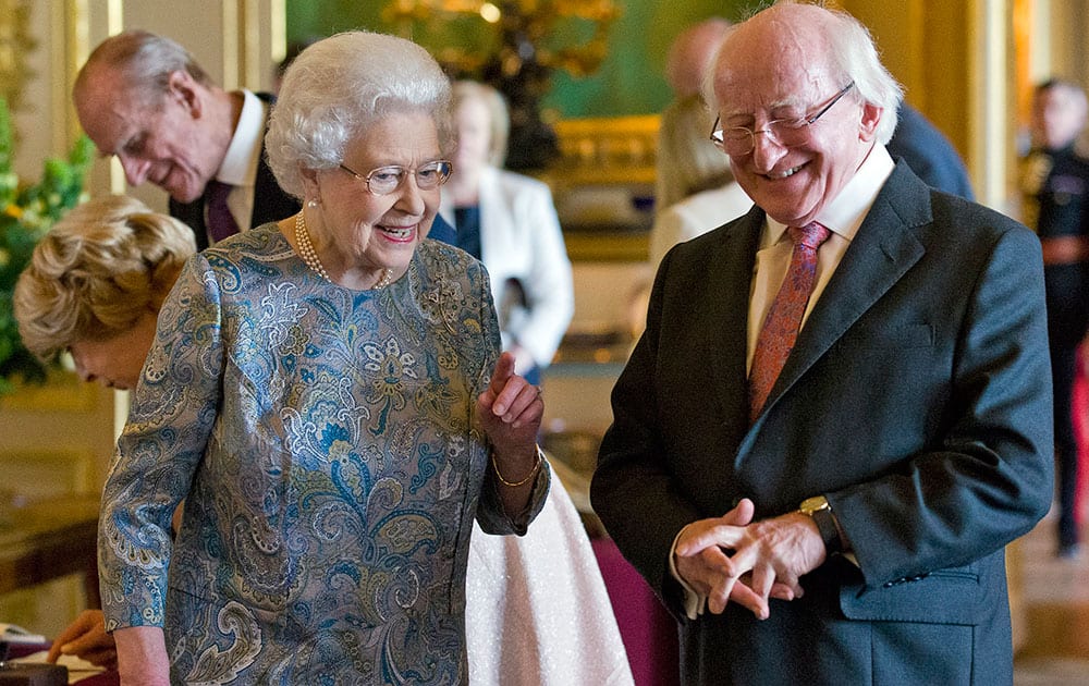 President of Ireland Michael D Higgins laughs with Britain`s Queen Elizabeth II as they view items of Irish interest extracted from the Royal Collection and displayed in the Green Drawing Room at Windsor Castle, in Windsor, England.