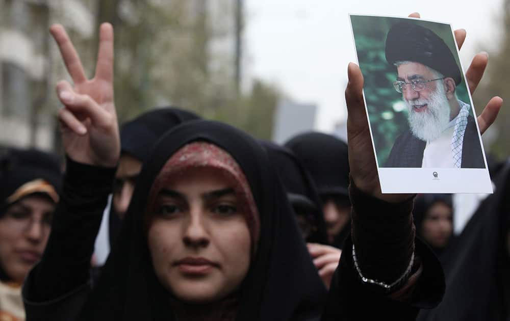 An Iranian woman holds a poster of supreme leader Ayatollah Ali Khamenei during a demonstration of hard-line university students protesting a human rights resolution passed by the European Parliament, in front of the Greek Embassy in Tehran, Iran.