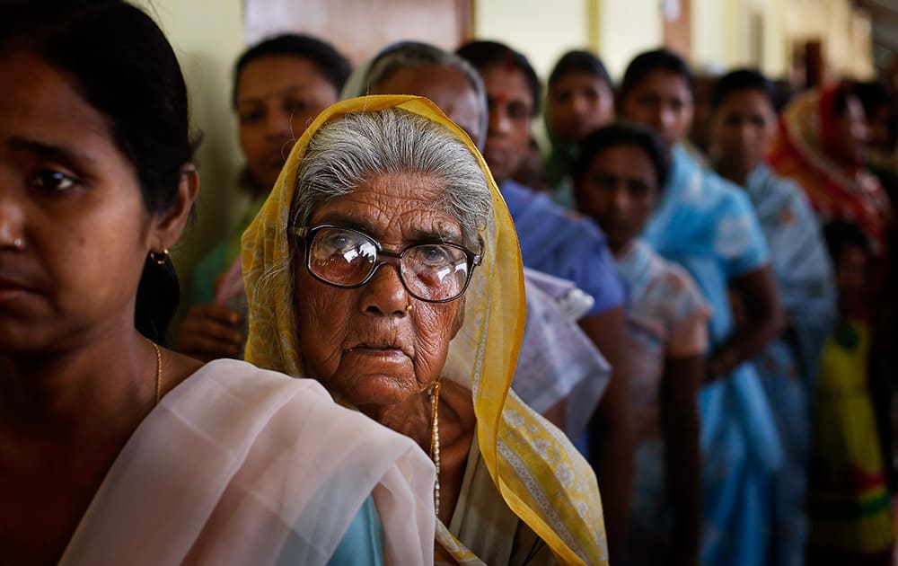 An elderly woman watches as she stands in a queue to cast her vote during the first phase of elections in Dibrugarh, in the northeastern state of Assam.
