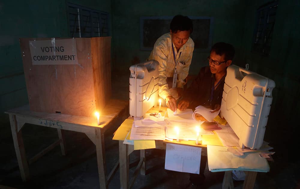 Polling officials check voting materials by candlelight next to electronic voting machines at a voting center on the eve of the second phase of Indian parliamentary elections at Senapati in north eastern Manipur.