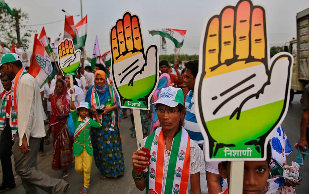 Supporters of India’s ruling Congress party carrying the `hand` party symbol dance during an election rally in Mumbai.