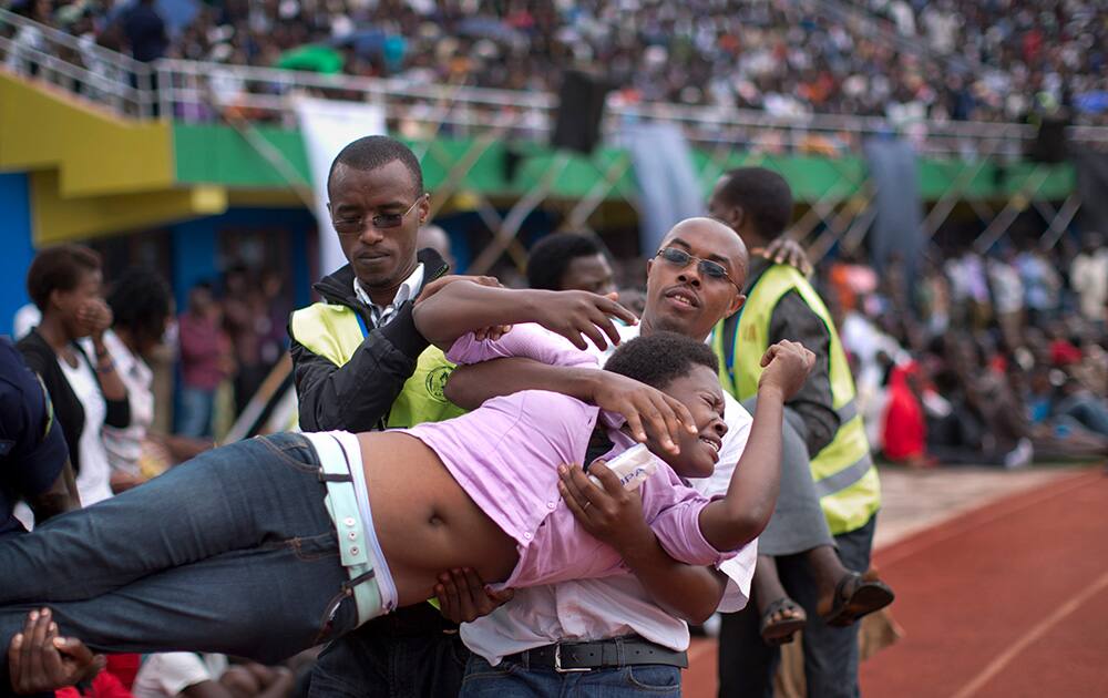 A wailing and distraught Rwandan woman, one of dozens overcome by grief at recalling the horror of the genocide, is carried away to receive help during a public ceremony to mark the 20th anniversary of the Rwandan genocide, at Amahoro stadium in Kigali, Rwanda.